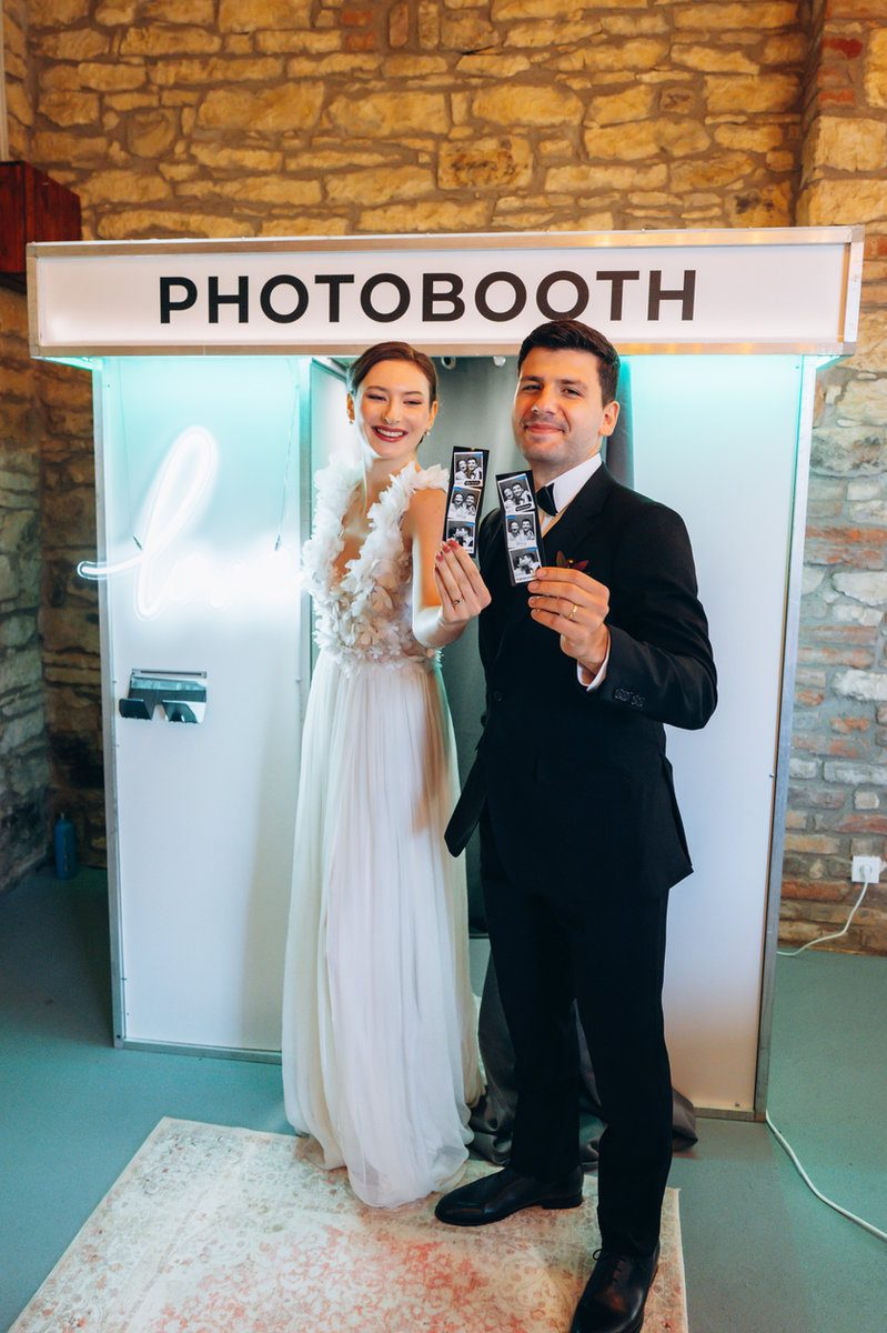 Svatební pár u fotokoutku s neonovým nápisem